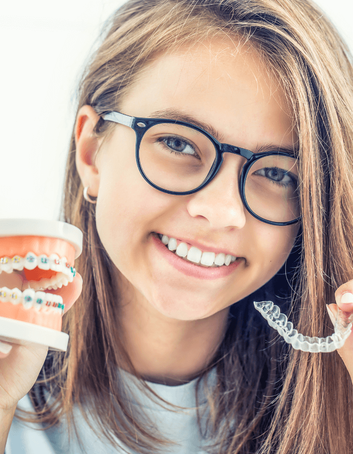 Una imagen de una niña con ortodoncia invisible y brackets